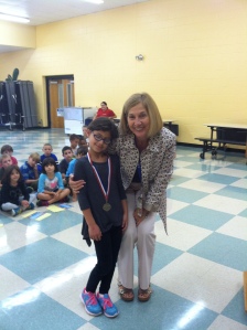 Lydia accepts her medal from Mrs. Frayne.